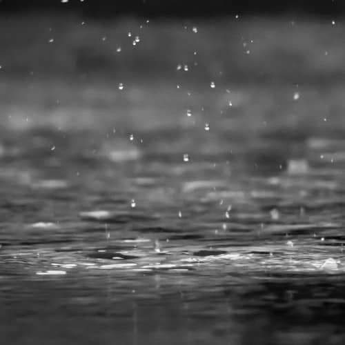 Photo de la pluie, sous un ciel gris, tombant sur le sol gris