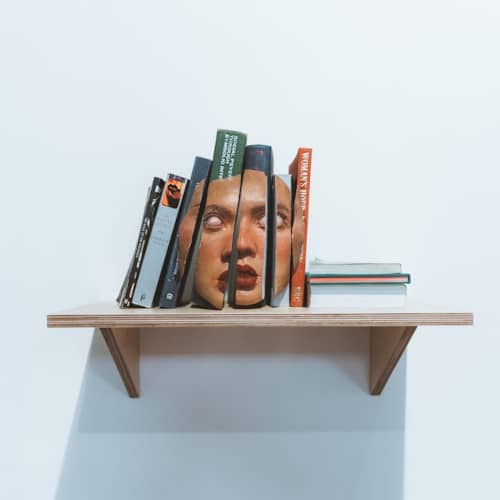 Photo d'un visage de femme décomposé sur le dos de plusieurs livres mal accolés