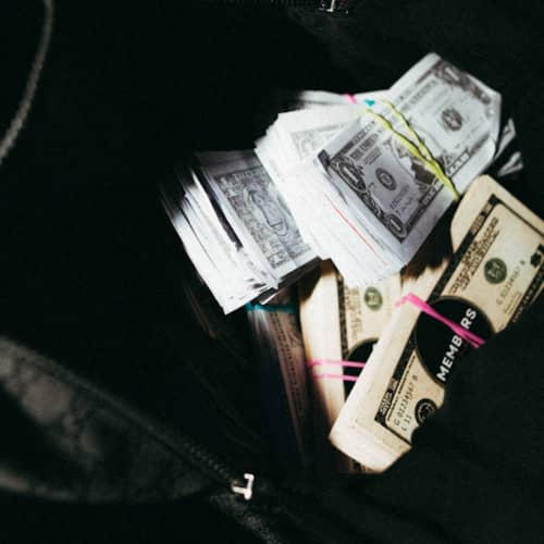 Photo de billets sortant d'un sac ouvert