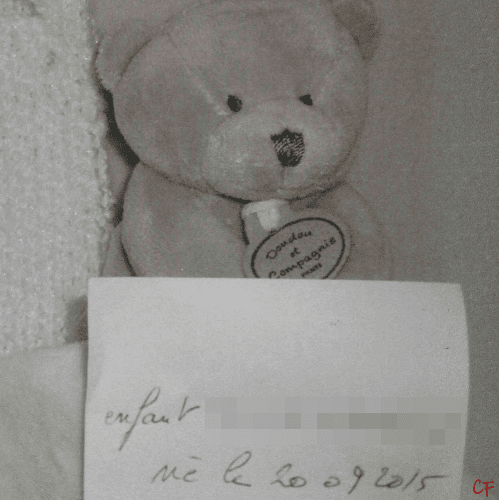 Photo d'un doudou nounours avec noté de façon manuscrite sur un papier posé sur lui : Enfant né le 20.09.2015