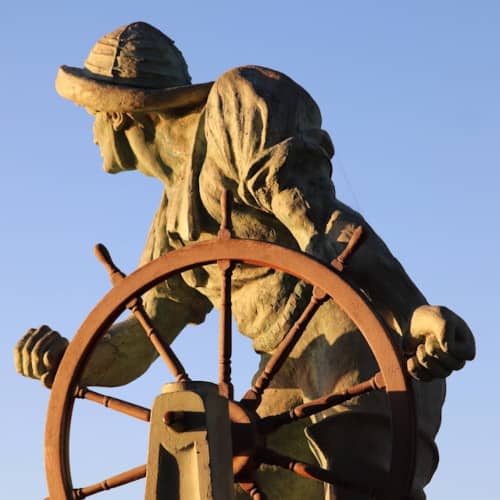 Photo d'une statue de matelot manoeuvrant une barre